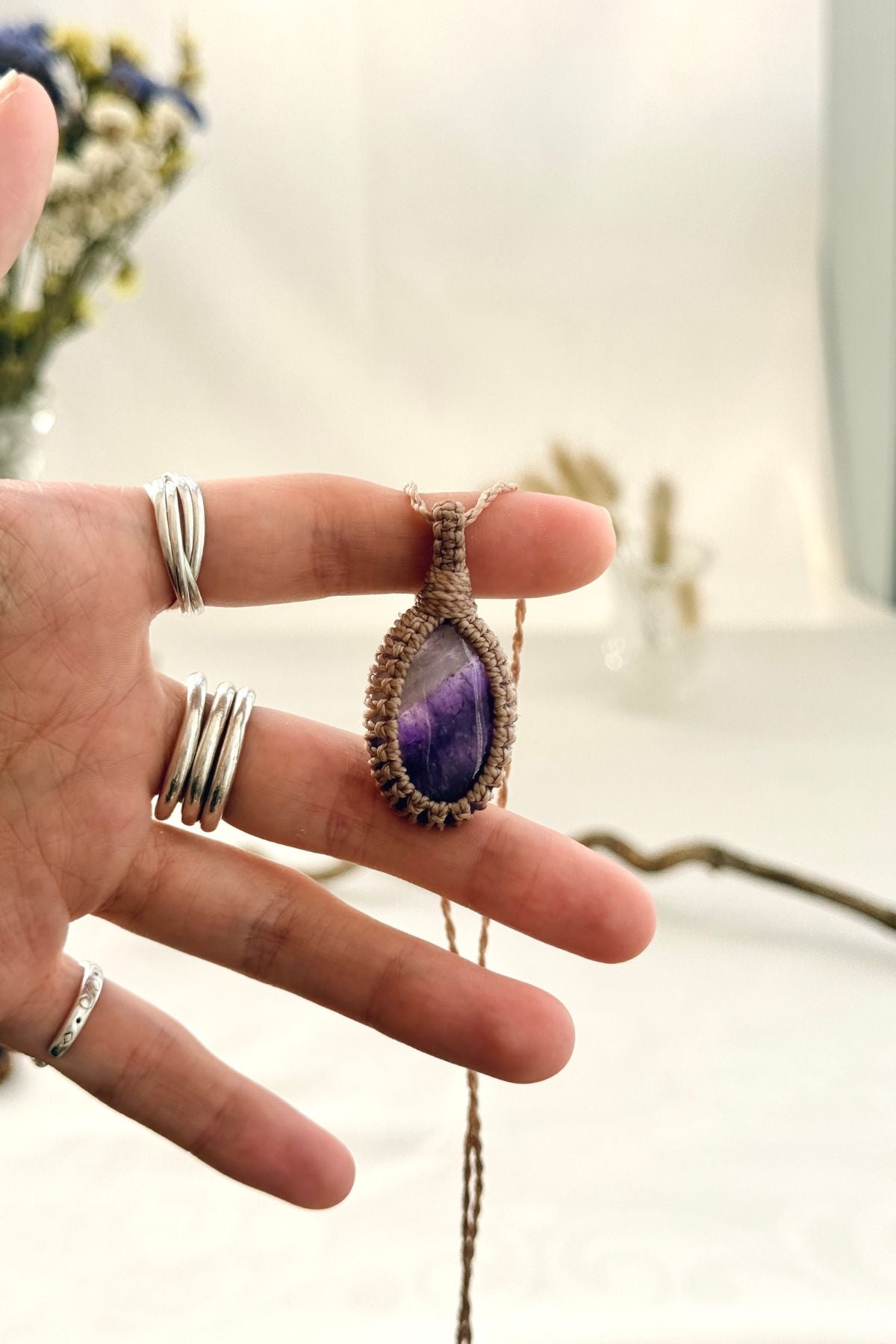 Handmade Chevron Amethyst macramé necklace held in hand, delicate natural gemstone jewelry