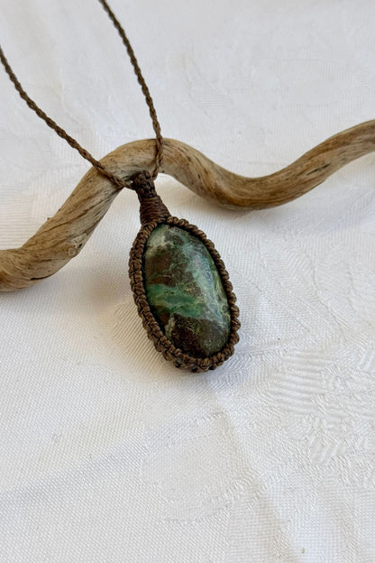Close-up of handmade Chrysocolla Macrame necklace, showcasing the intricate macrame knotting and the vibrant patterns of the gemstone.