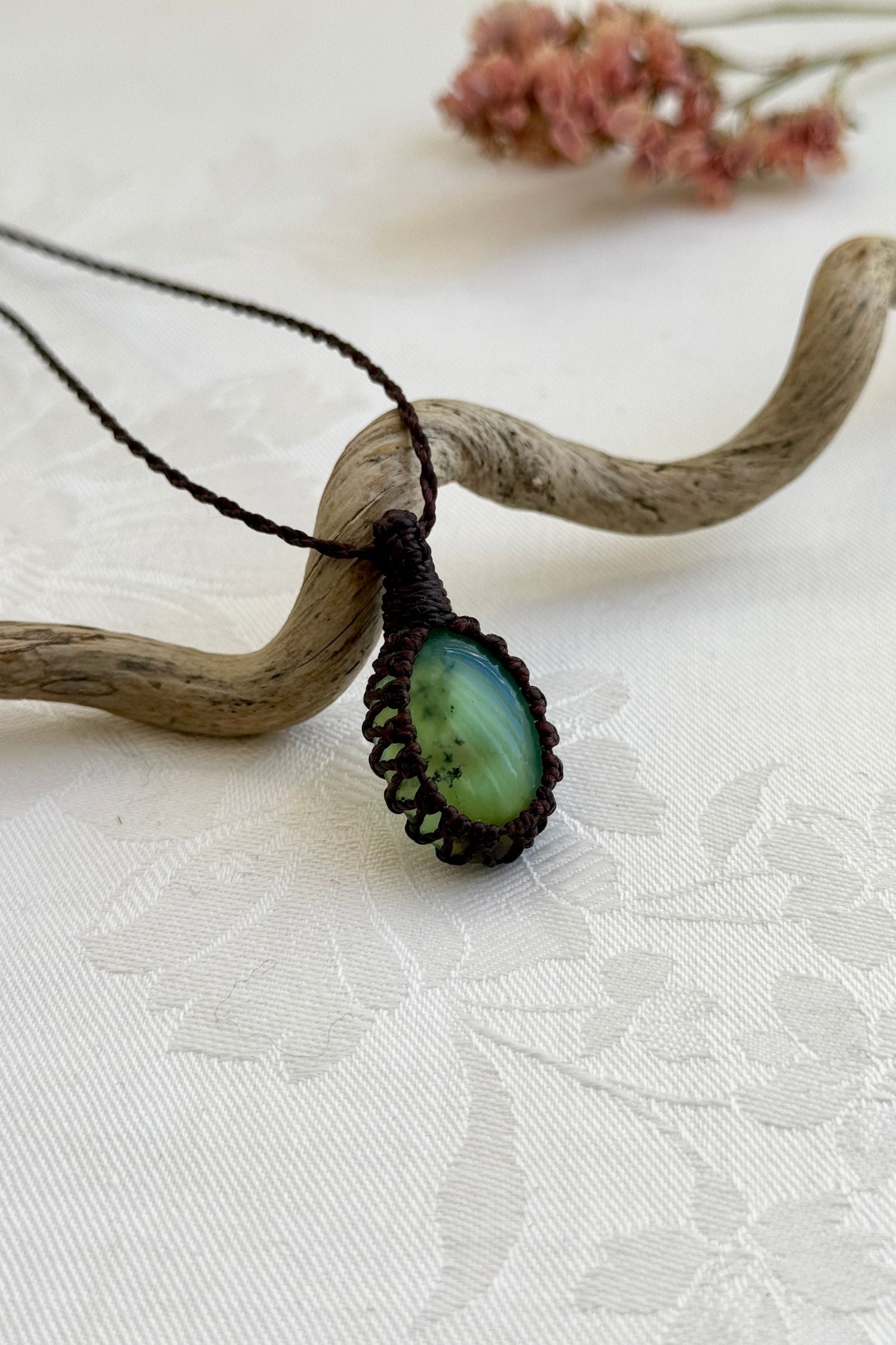 Side view of a Chrysoprase macrame necklace wrapped in brown cord, highlighting its elegant craftsmanship.