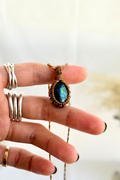Hand holding a handmade Labradorite Macrame necklace from the Essence collection, featuring a high-quality gemstone in a delicate everyday-wear design.