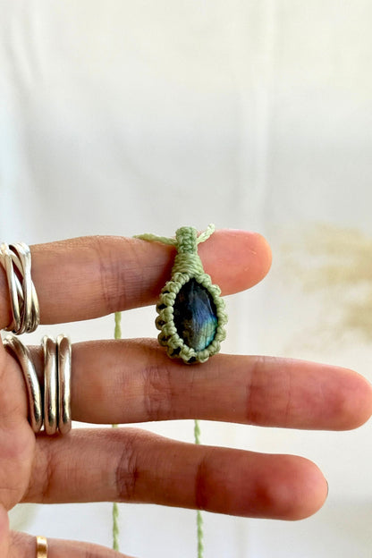 Hand holding a handmade Labradorite Macrame necklace from the Essence collection, featuring a high-quality gemstone in a delicate everyday-wear design.