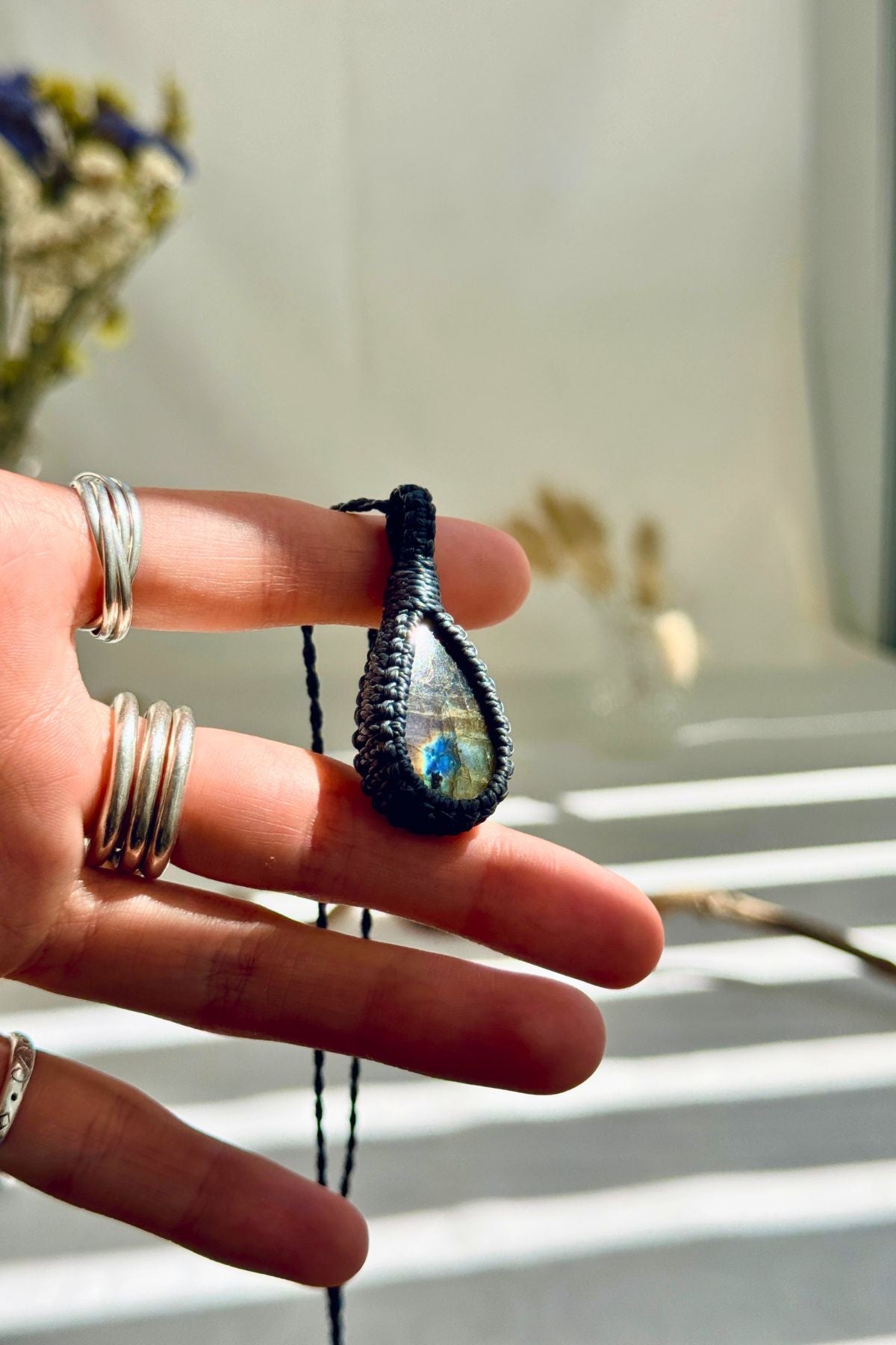 Handmade Labradorite macramé necklace held in hand, delicate natural gemstone jewelry