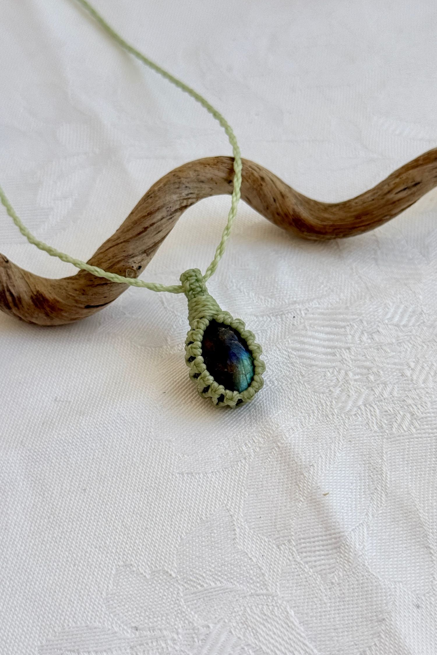Side angle view of the Labradorite Macrame necklace, showing the fine macrame details and the unique gemstone centerpiece.