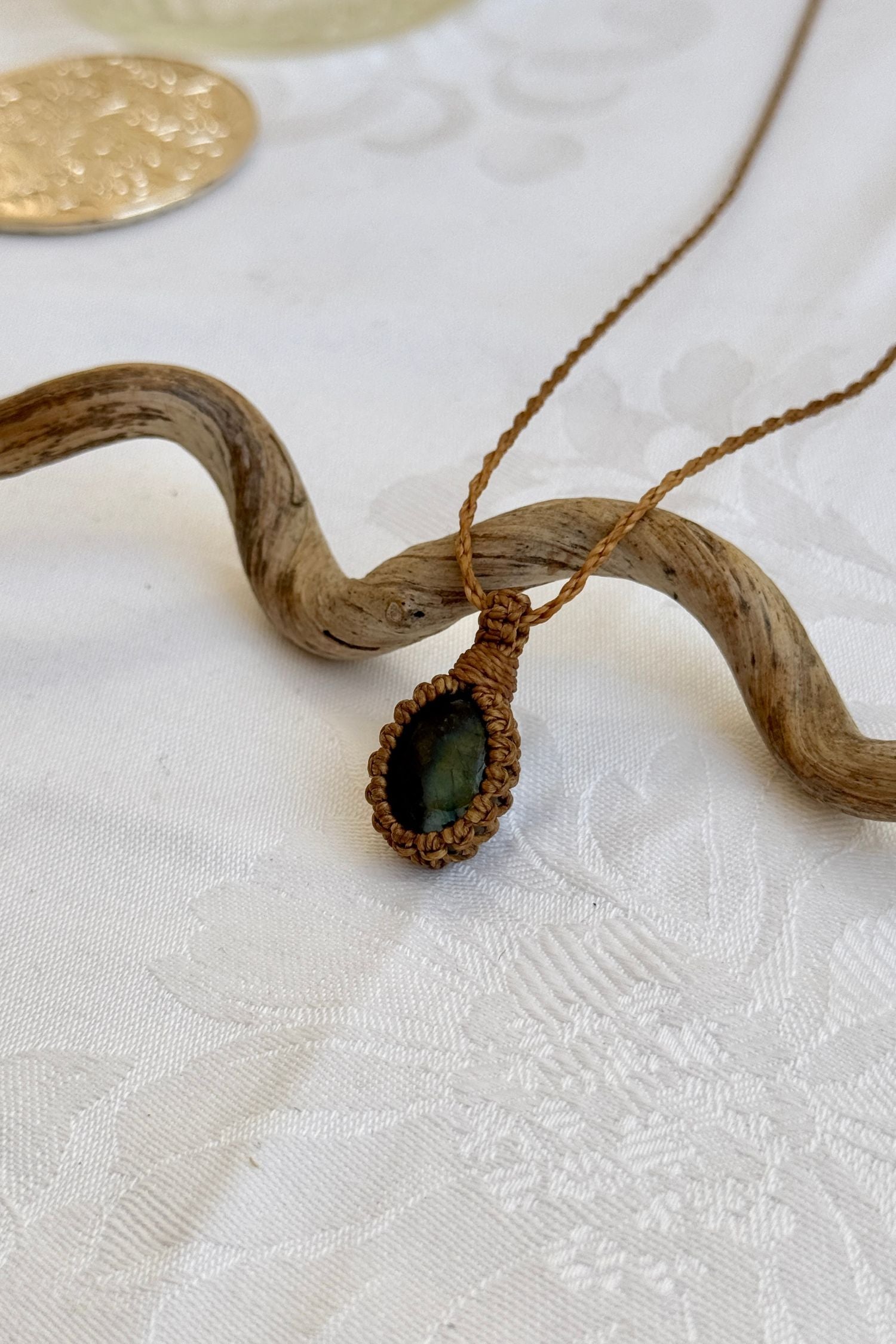 Side angle view of the Labradorite Macrame necklace, showing the fine macrame details and the unique gemstone centerpiece.