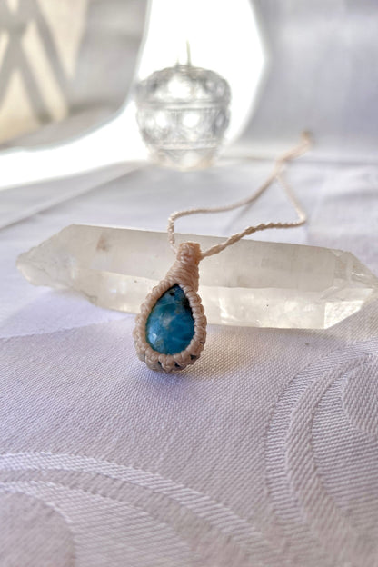 Side angle view of the Larimar Macrame necklace, showing the fine macrame details and the unique blue gemstone centerpiece.