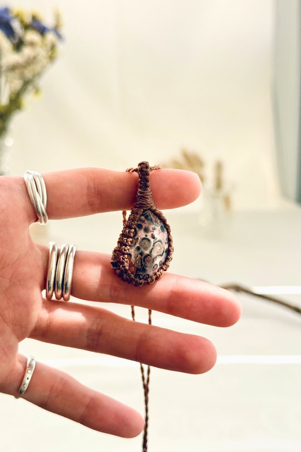 Handmade Leopard Jasper macramé necklace held in hand, delicate natural gemstone jewelry