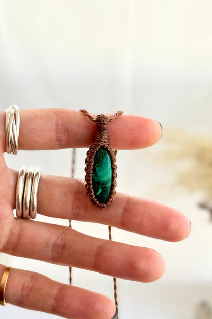 Hand holding a handmade Malachite Macrame necklace from the Essence collection, featuring a high-quality gemstone in a delicate everyday-wear design.