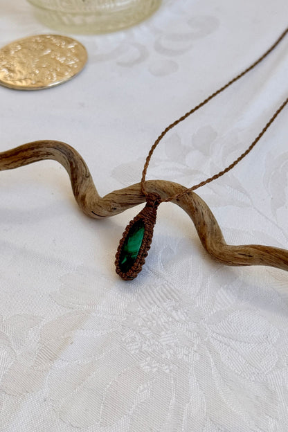 Side angle view of the Malachite Macrame necklace, showing the fine macrame details and the unique gemstone centerpiece.