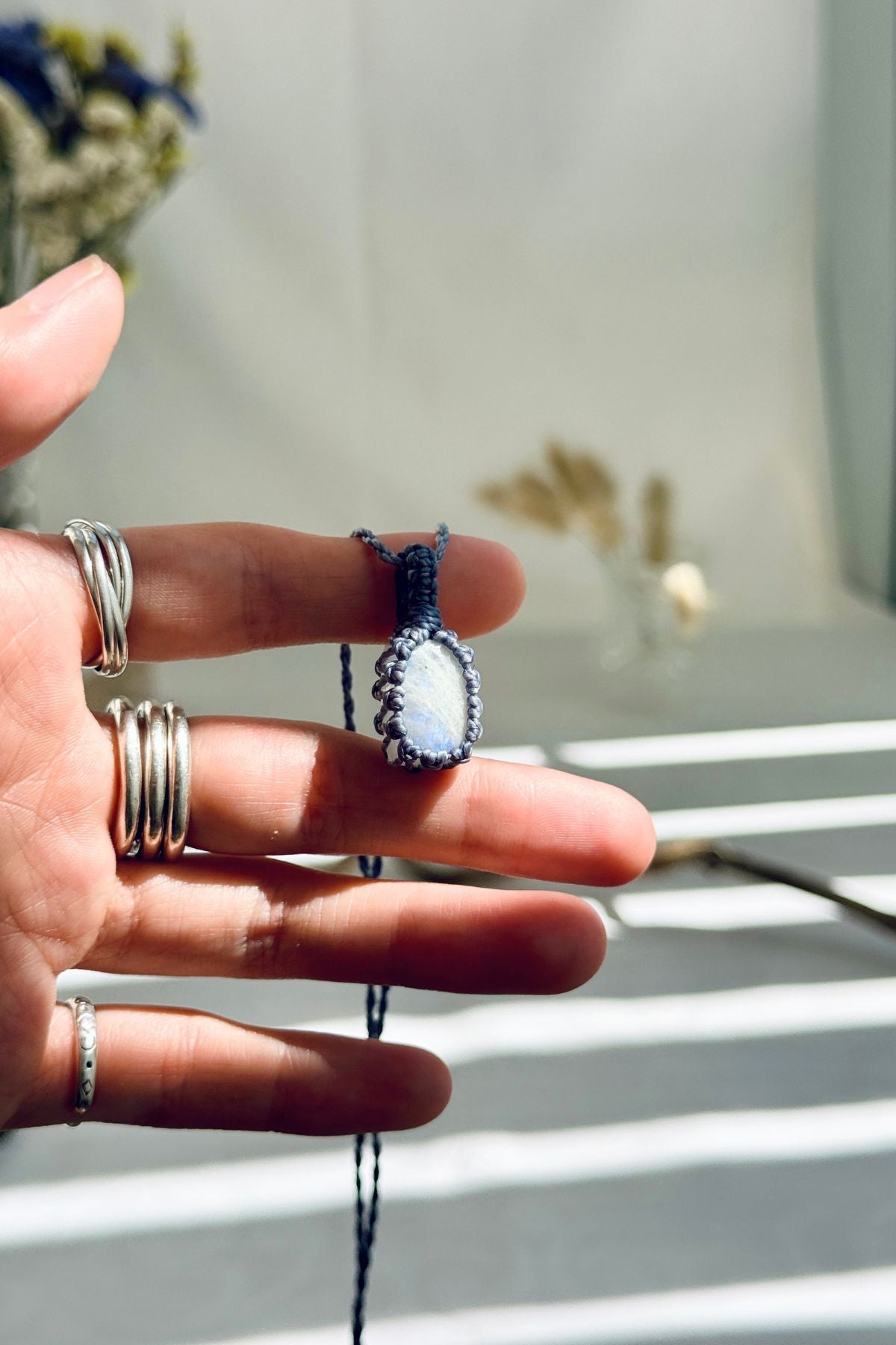 Handmade Moonstone macramé necklace held in hand, delicate natural gemstone jewelry