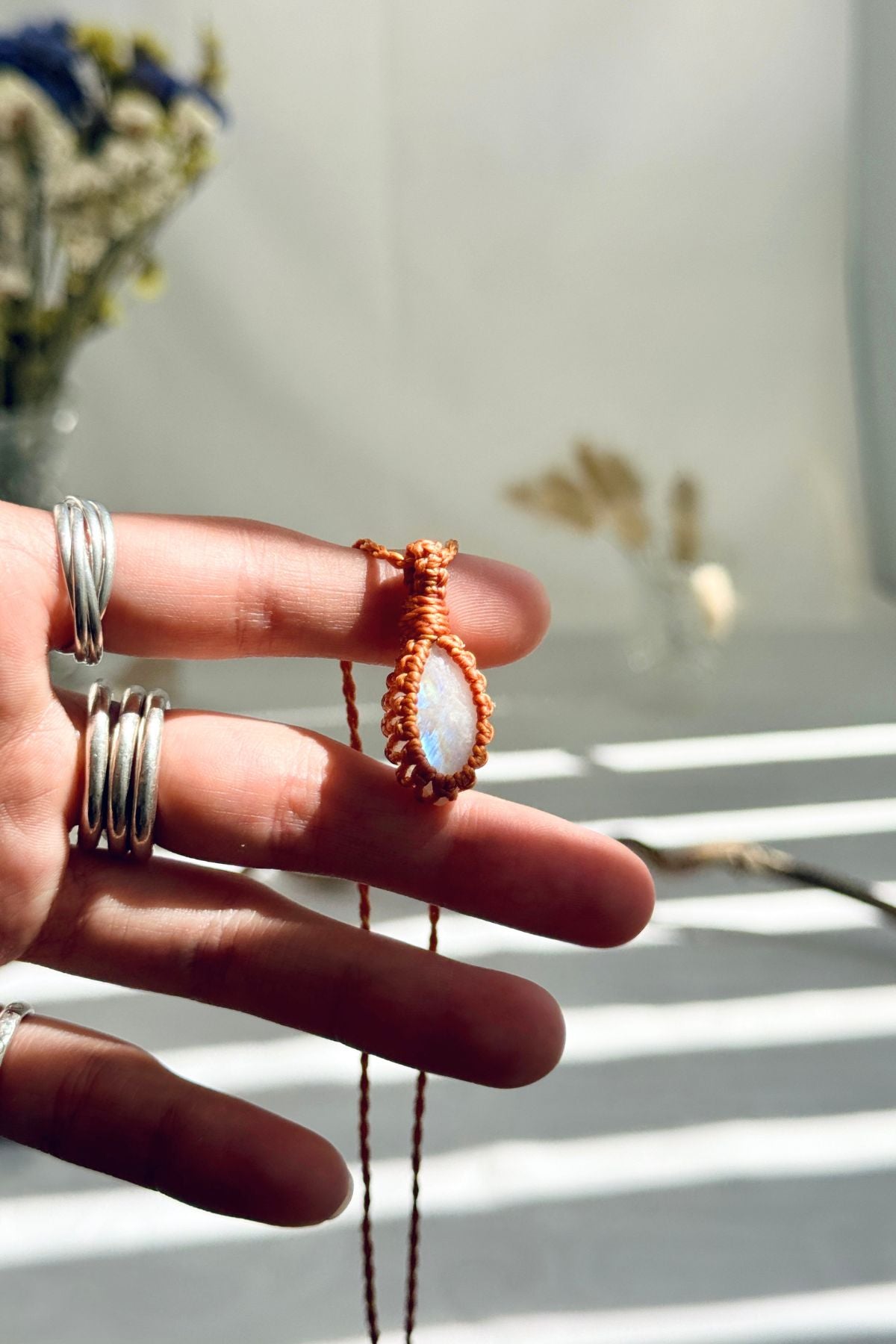Handmade Moonstone macramé necklace held in hand, delicate natural gemstone jewelry