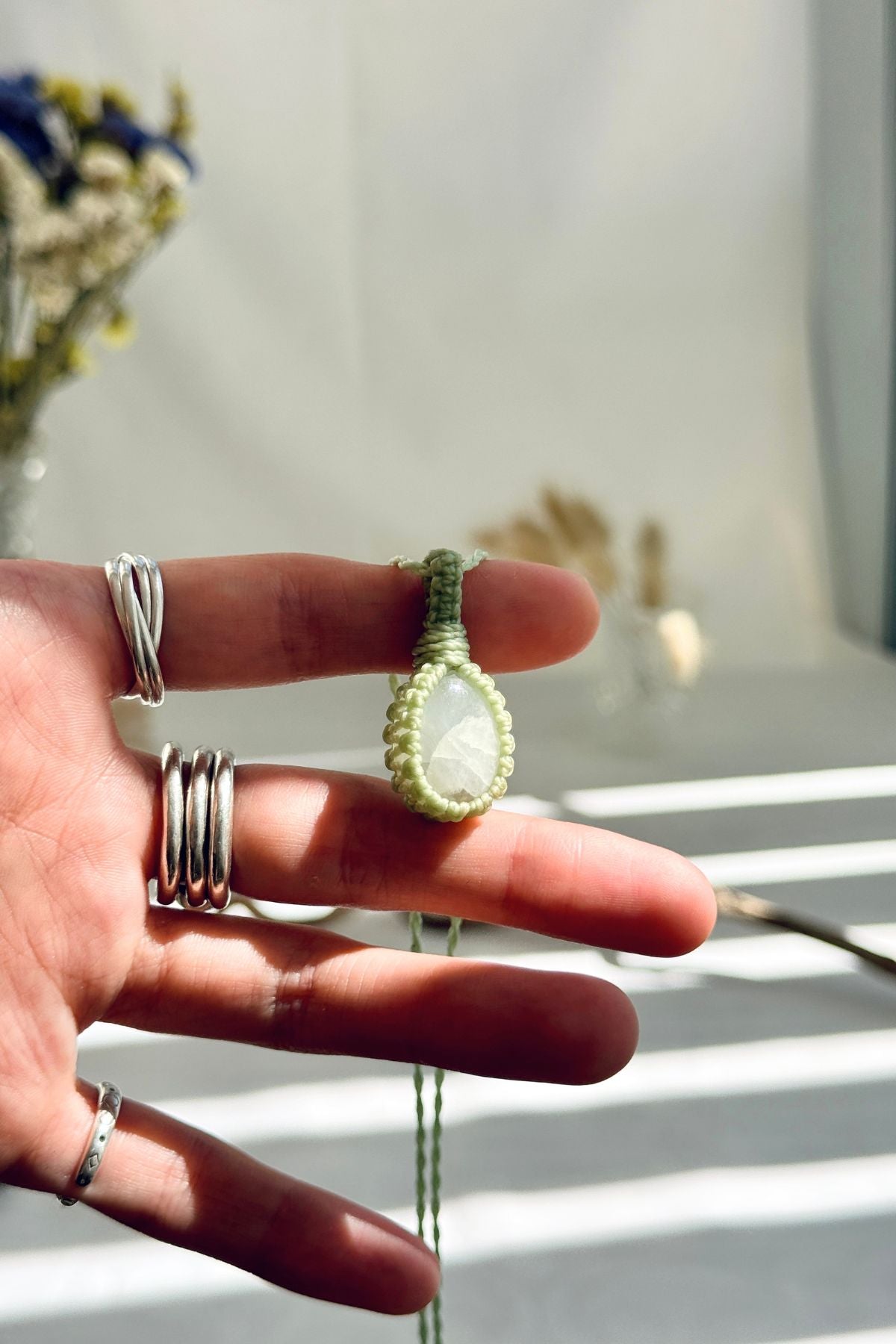 Handmade Moonstone macramé necklace held in hand, delicate natural gemstone jewelry