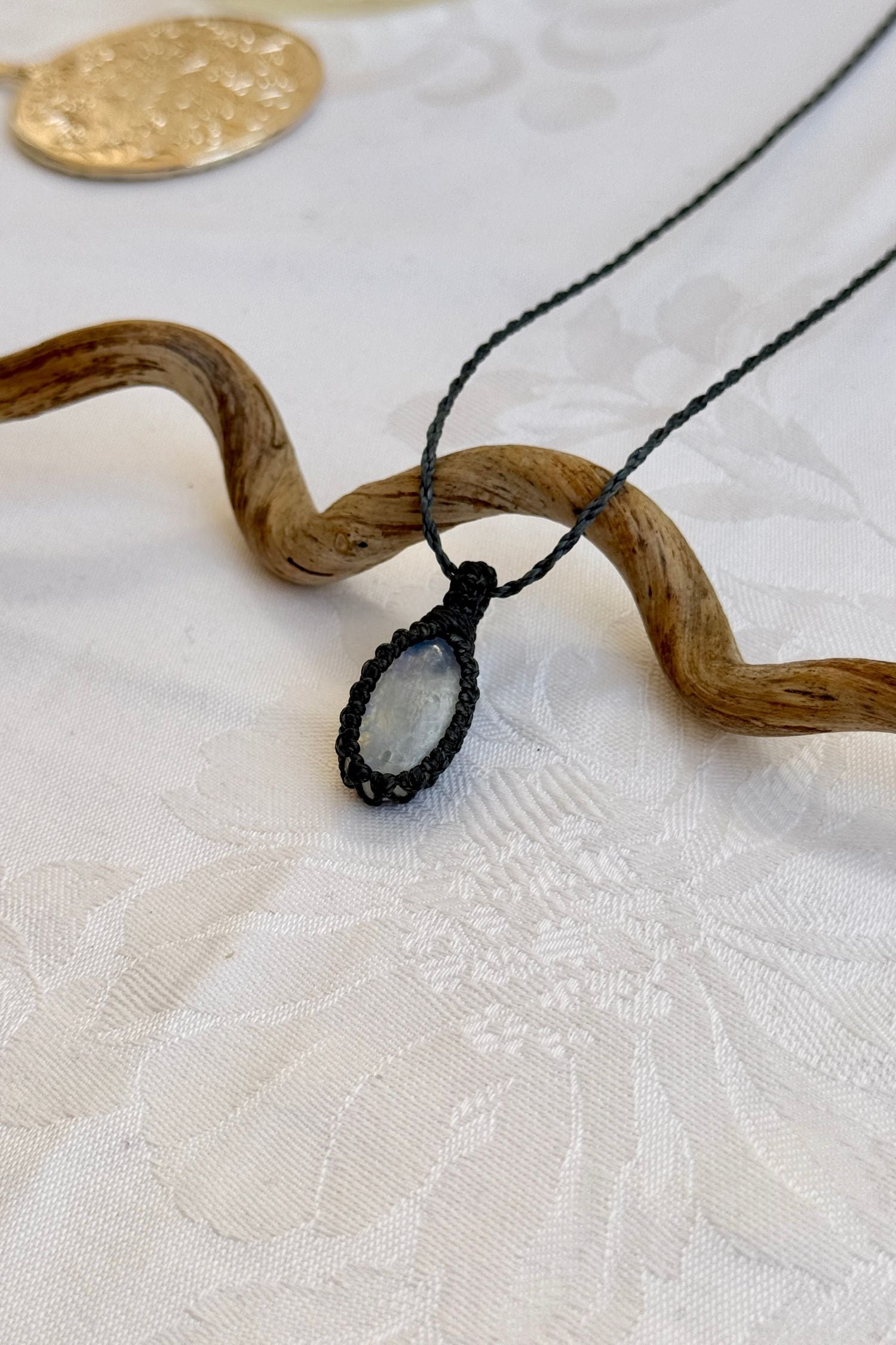 Side angle view of the Moonstone Macrame necklace, showing the fine macrame details and the unique gemstone centerpiece.