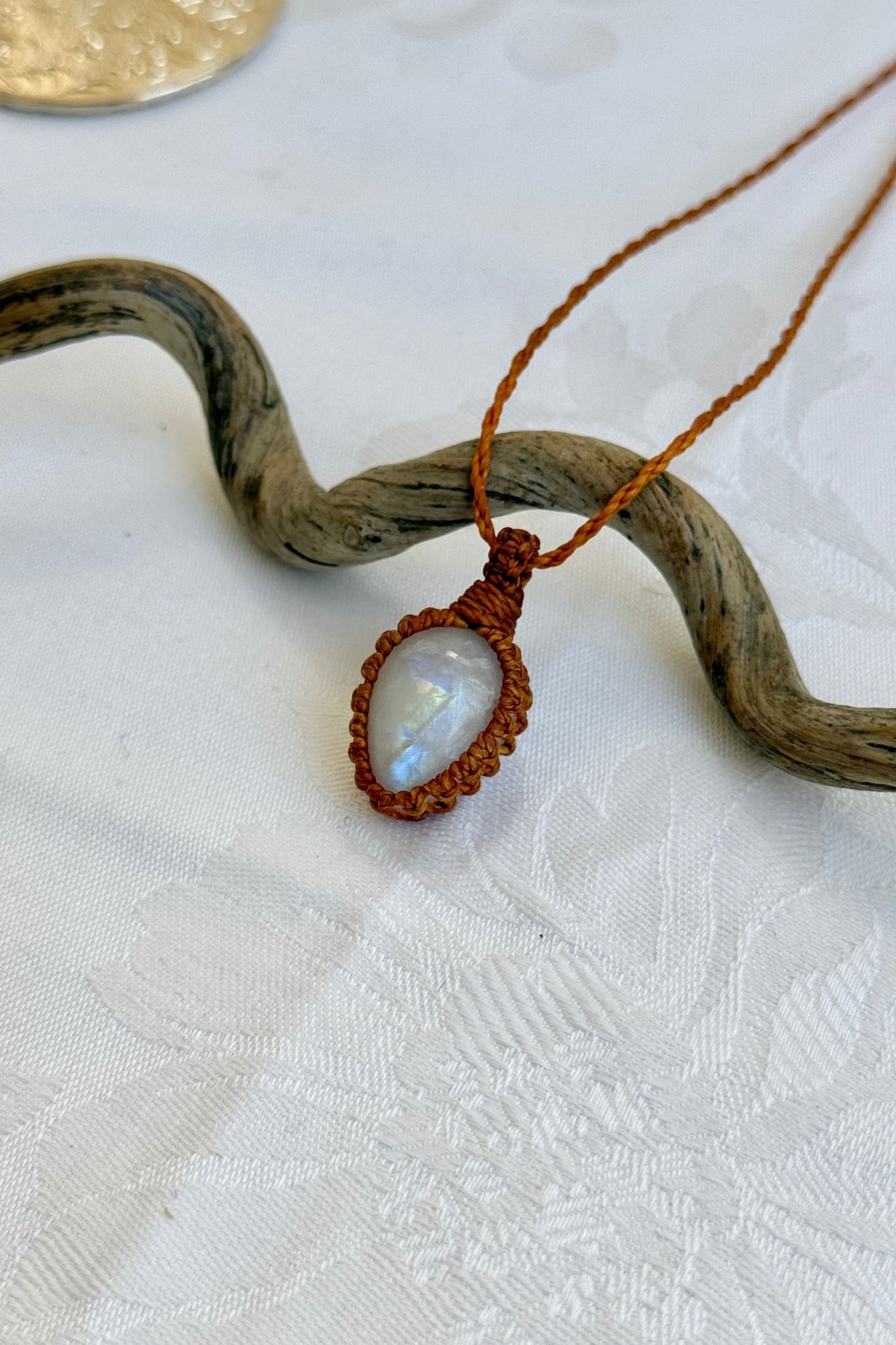 Close-up of handmade Moonstone Macrame necklace, showcasing the intricate macrame knotting and the vibrant patterns of the gemstone.