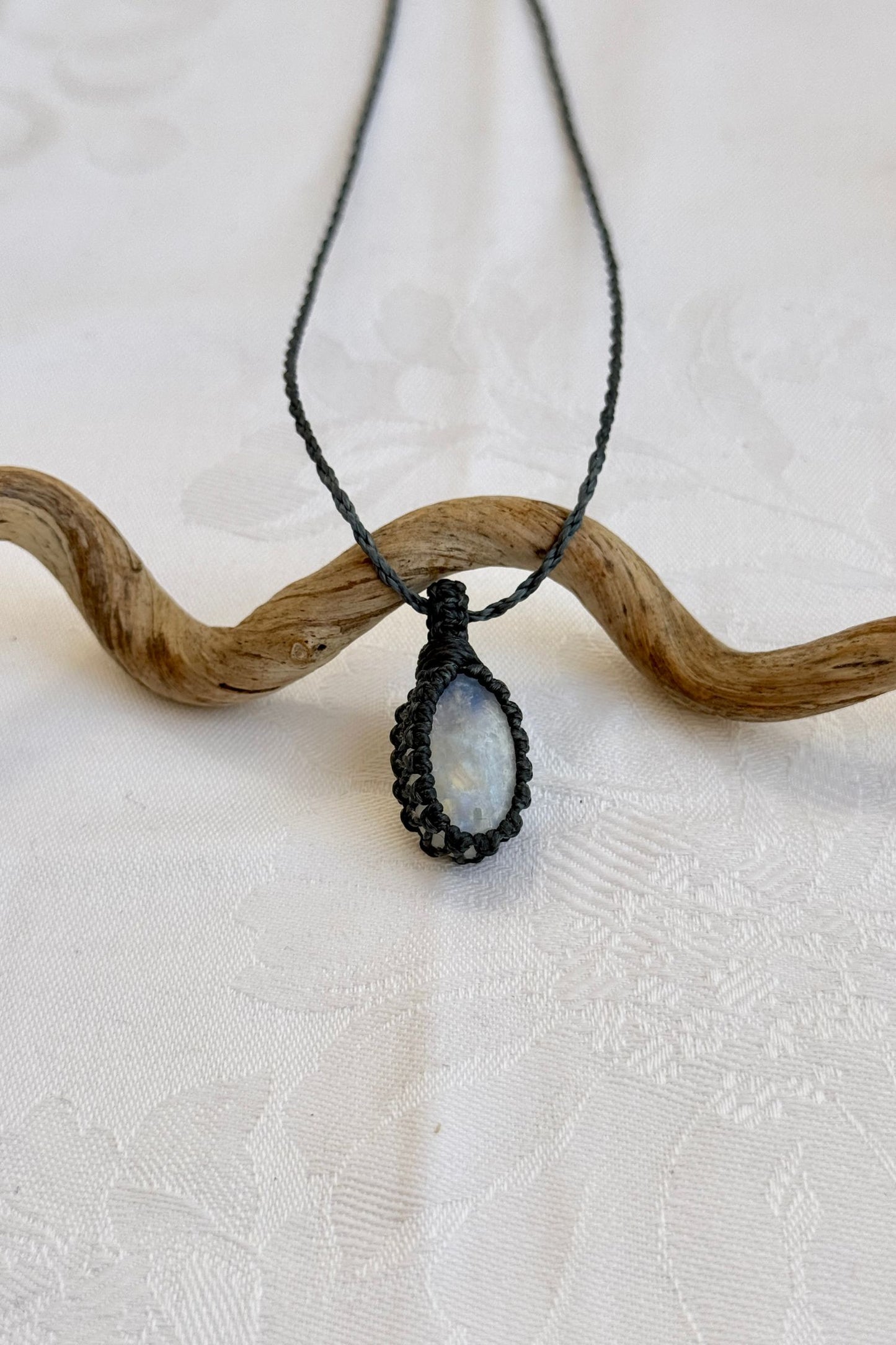 Close-up of handmade Moonstone Macrame necklace, showcasing the intricate macrame knotting and the vibrant patterns of the gemstone.