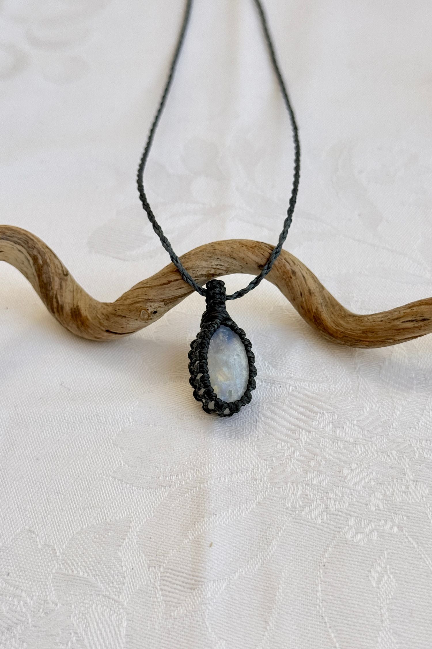 Close-up of handmade Moonstone Macrame necklace, showcasing the intricate macrame knotting and the vibrant patterns of the gemstone.