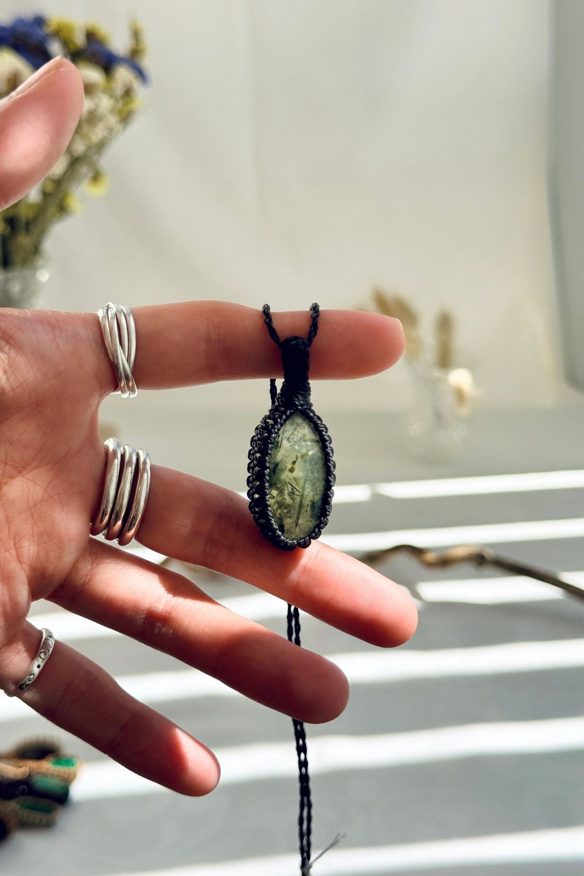 Handmade Prehnite macramé necklace held in hand, delicate natural gemstone jewelry