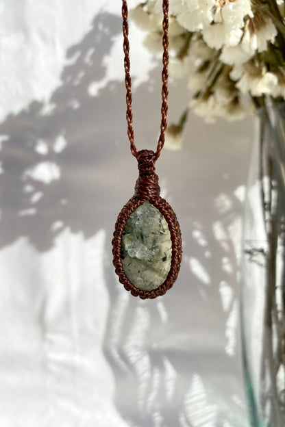 Handmade Prehnite macrame necklace displayed on a clean background, highlighting the gemstone’s soft green hue and intricate macrame design.