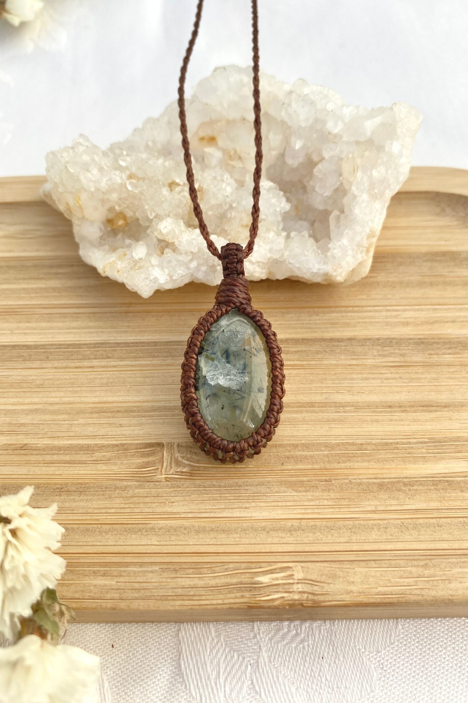 Handmade Prehnite macrame necklace laid flat, showcasing its minimalist design and natural gemstone centerpiece.