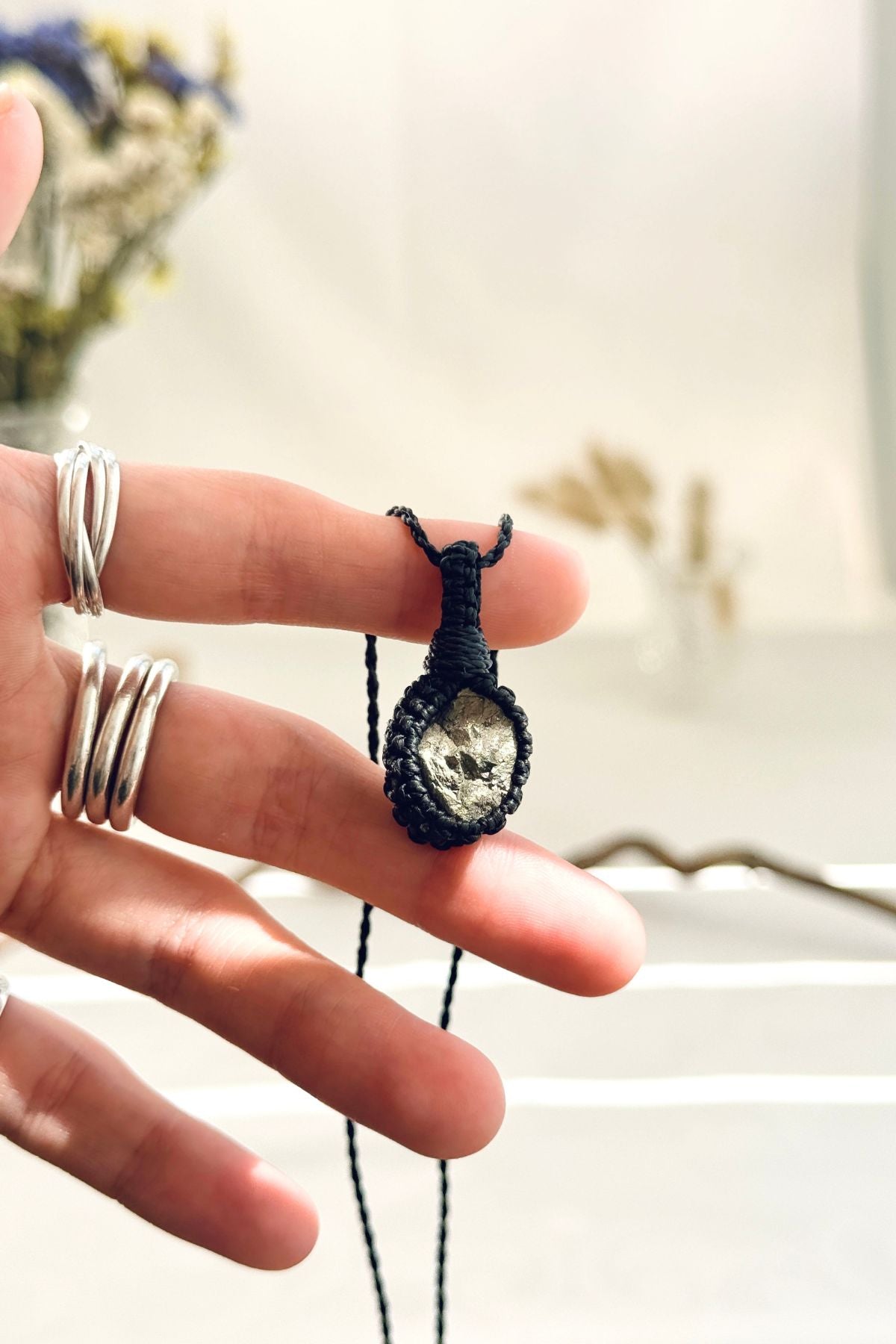 Handmade Pyrite macramé necklace held in hand, delicate natural gemstone jewelry