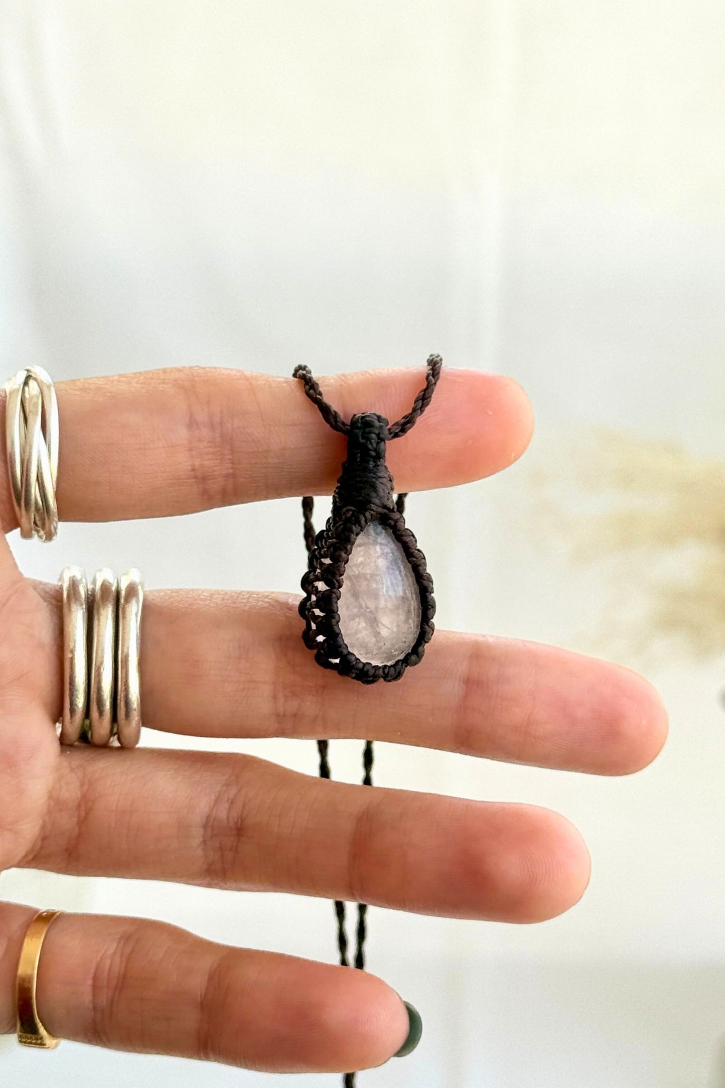 Hand holding a handmade Rose Quartz Macrame necklace from the Essence collection, featuring a high-quality gemstone in a delicate everyday-wear design.