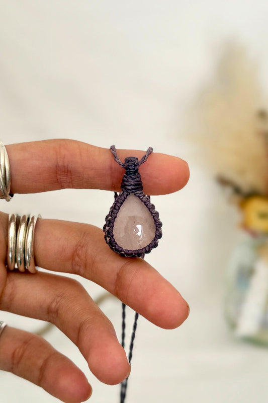 Hand holding a handmade Rose Quartz Macrame necklace from the Essence collection, featuring a high-quality gemstone in a delicate everyday-wear design.