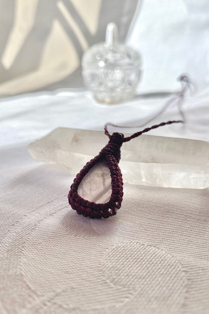 Another side angle shot of the rose quartz macrame necklace, showing the smooth, soft pink hues of the natural gemstone.