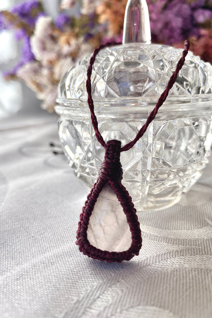 Handmade rose quartz macrame necklace displayed standing, showcasing the refined macrame work and elegant gemstone centerpiece.