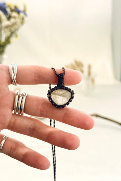 Handmade Rutilated Quartz macramé necklace held in hand, delicate natural gemstone jewelry