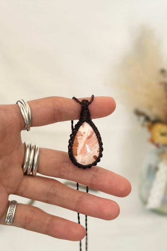 Hand holding a handmade rare Scolecite Macrame necklace from the Essence collection, featuring a high-quality gemstone in a delicate everyday-wear design.