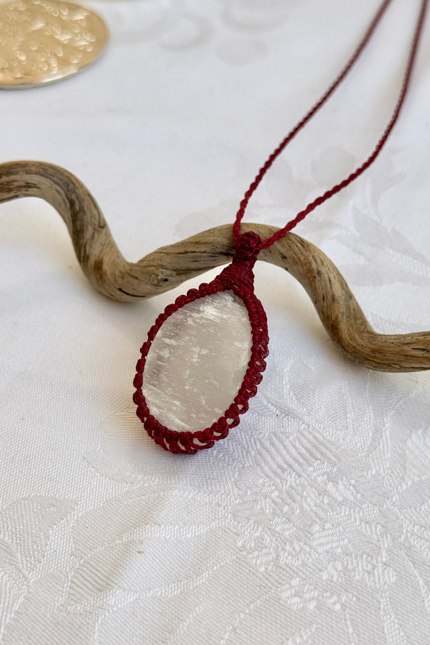 Side angle view of the Selenite Macrame necklace, showing the fine macrame details and the unique gemstone centerpiece.