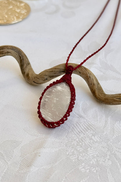 Side angle view of the Selenite Macrame necklace, showing the fine macrame details and the unique gemstone centerpiece.