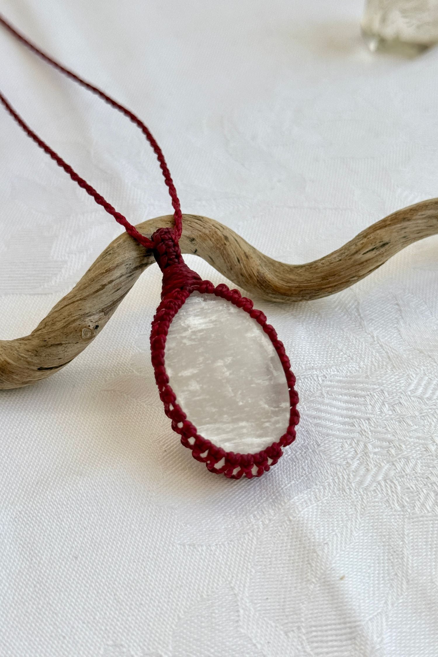 Close-up of handmade Selenite Macrame necklace, showcasing the intricate macrame knotting and the vibrant patterns of the gemstone.
