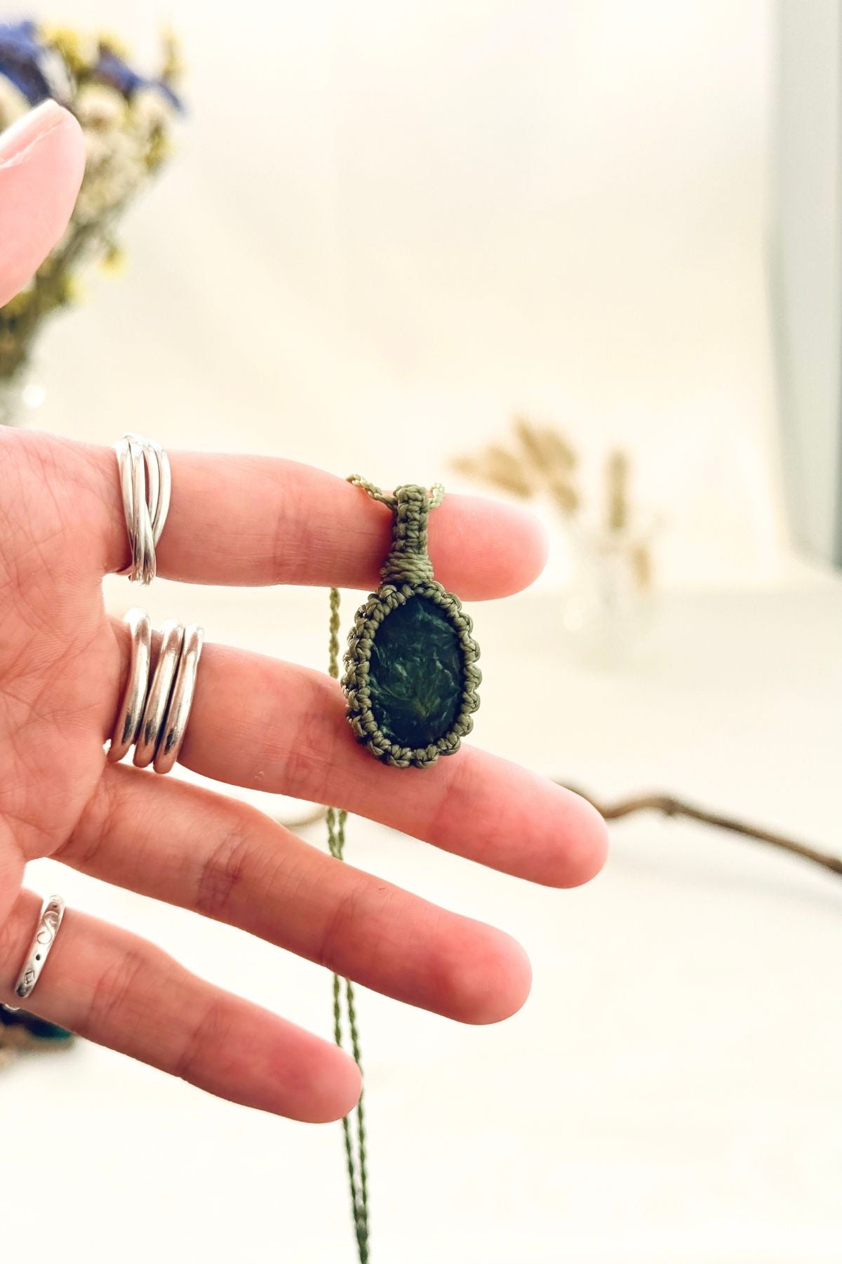 Handmade Seraphinite macramé necklace held in hand, delicate natural gemstone jewelry