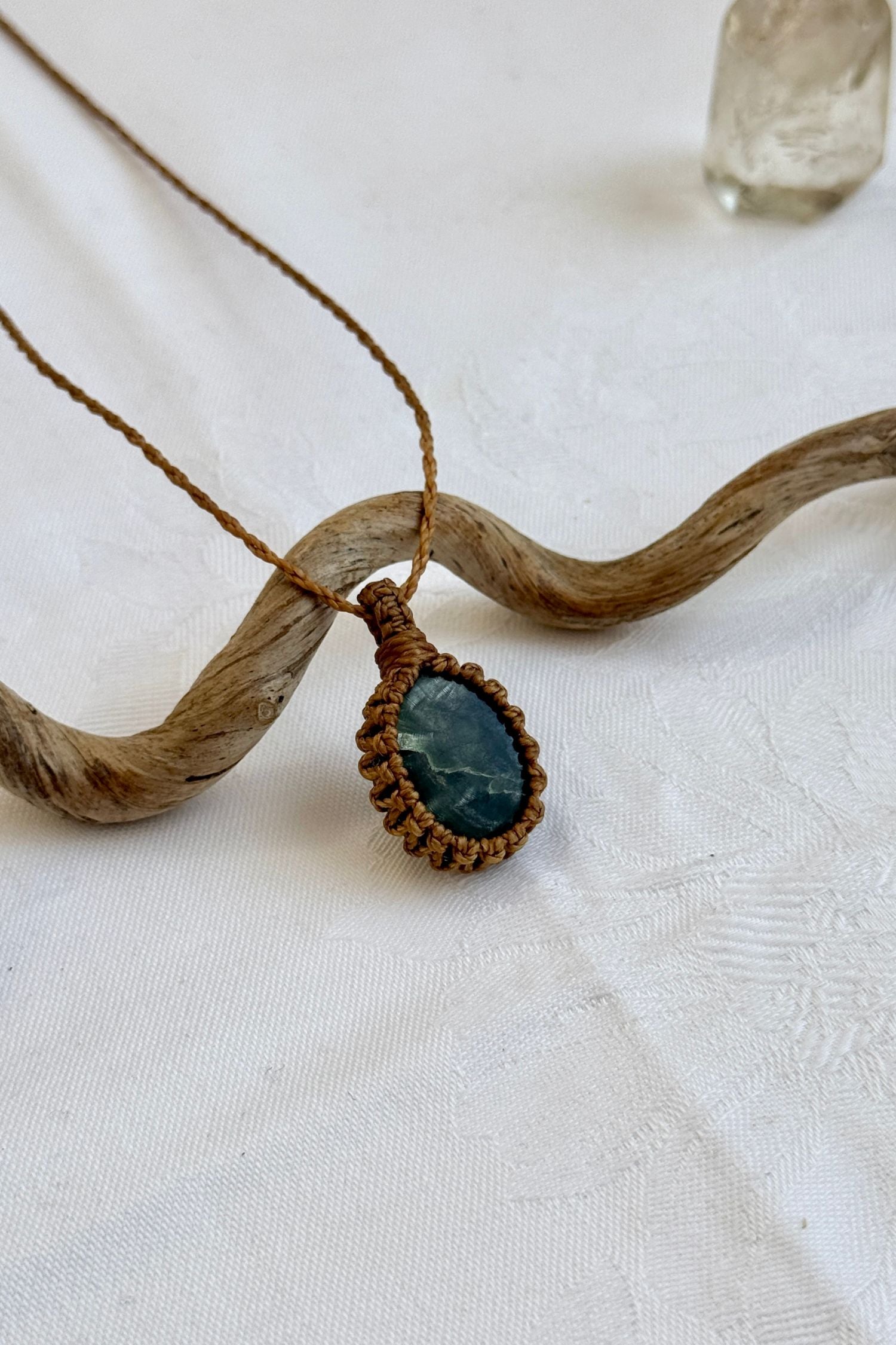Side angle view of the Seraphinite Macrame necklace, showing the fine macrame details and the unique gemstone centerpiece.