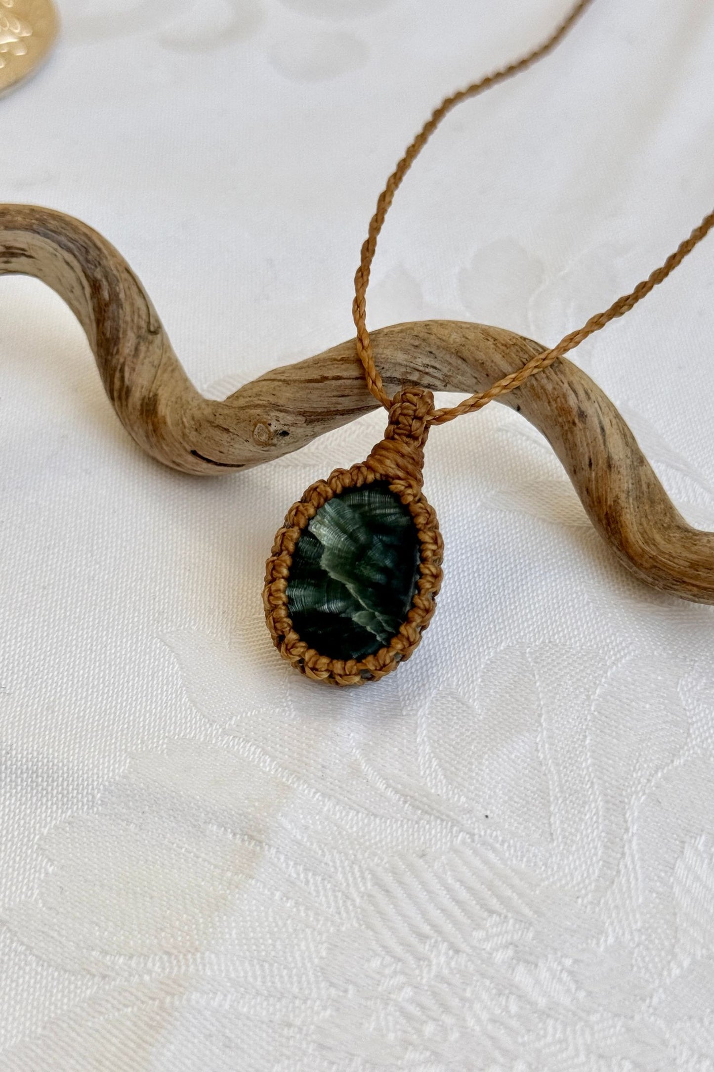 Close-up of handmade Seraphinite Macrame necklace, showcasing the intricate macrame knotting and the vibrant patterns of the gemstone.