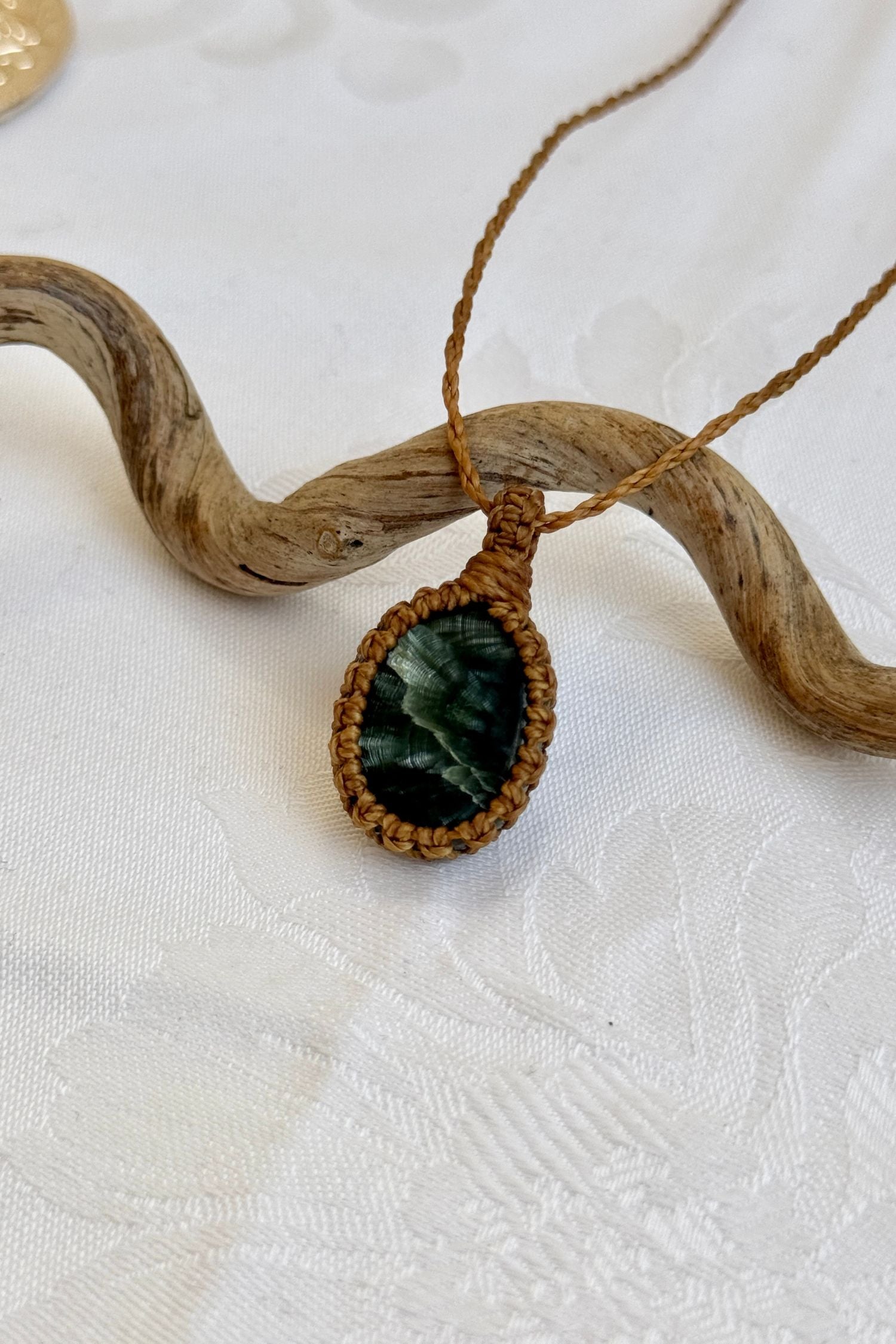 Close-up of handmade Seraphinite Macrame necklace, showcasing the intricate macrame knotting and the vibrant patterns of the gemstone.