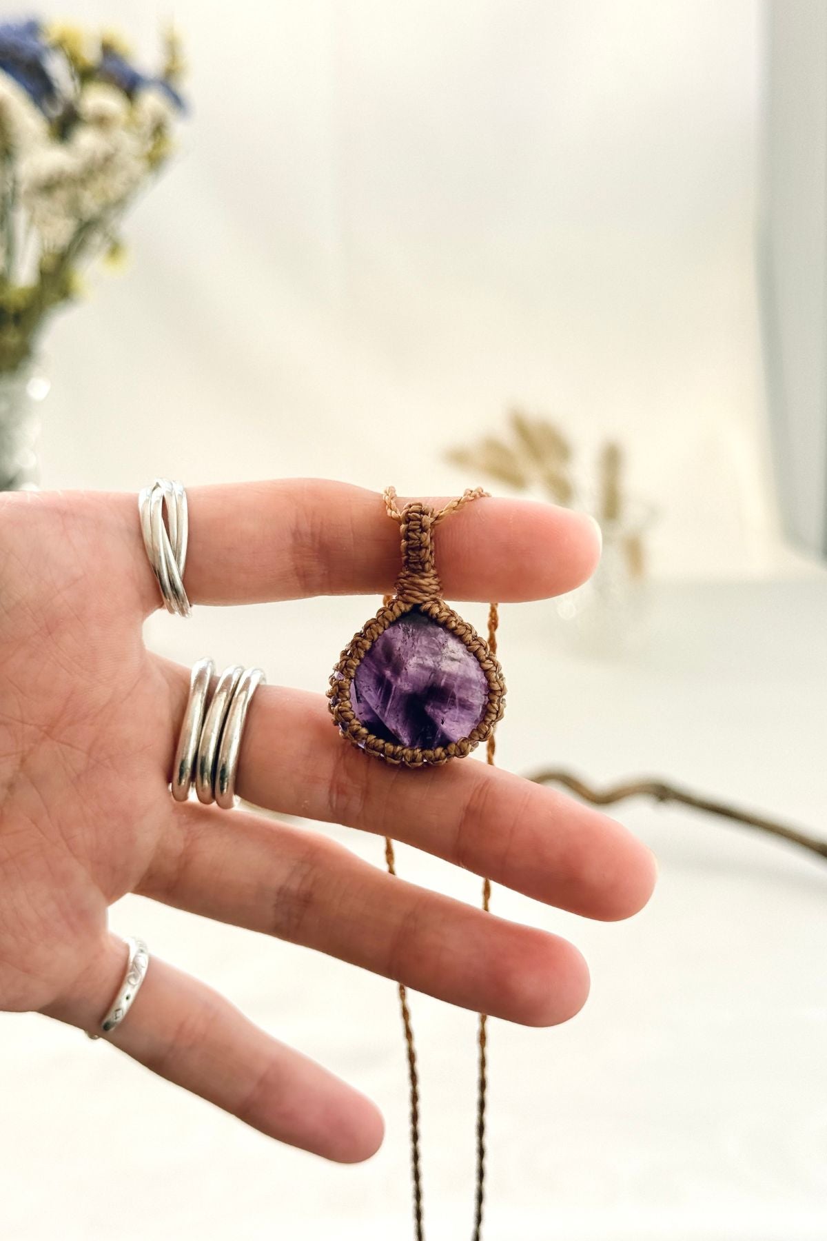 Handmade Star Amethyst macramé necklace held in hand, delicate natural gemstone jewelry