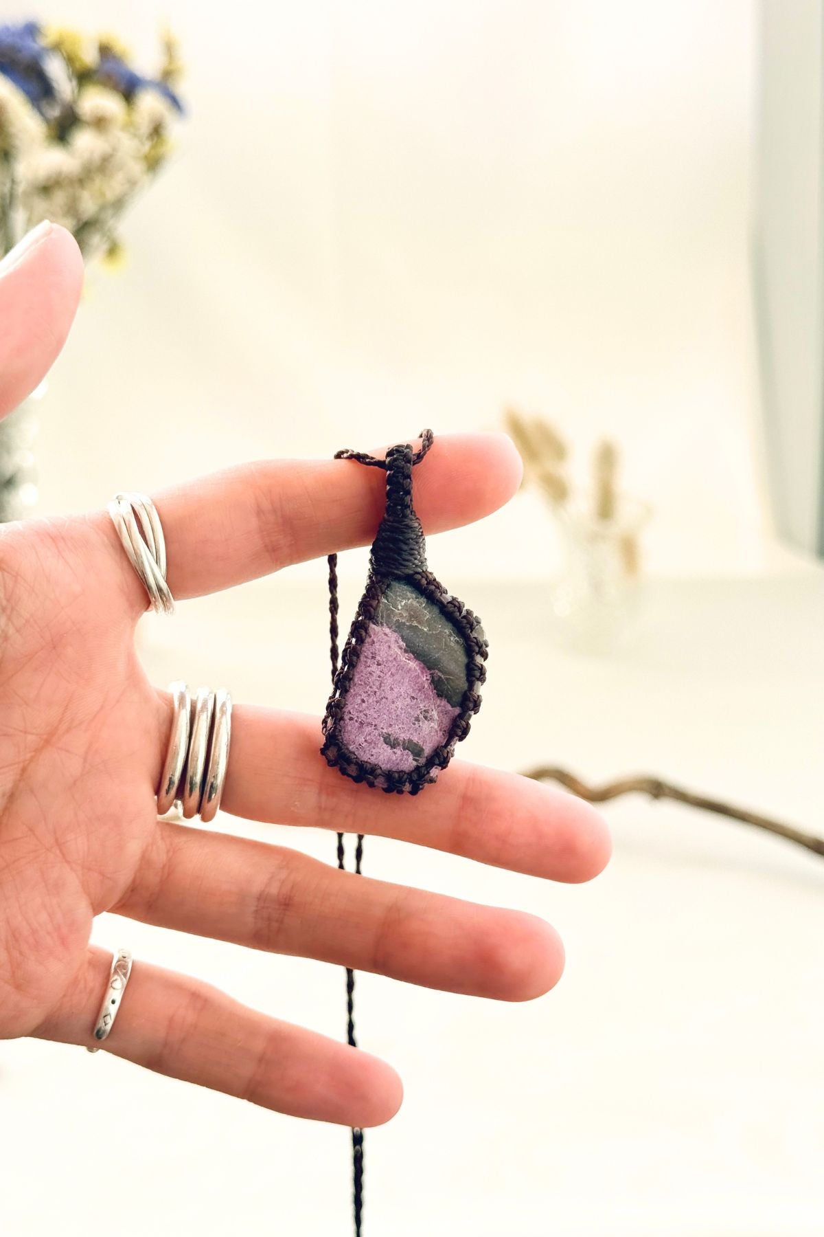 Handmade Stichtite macramé necklace held in hand, delicate natural gemstone jewelry