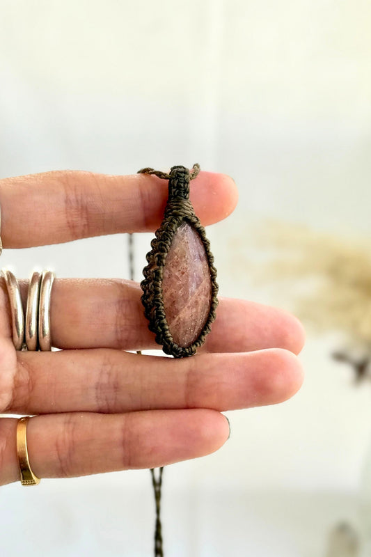 Hand holding a handmade Sunstone Macrame necklace from the Essence collection, featuring a high-quality gemstone in a delicate everyday-wear design.