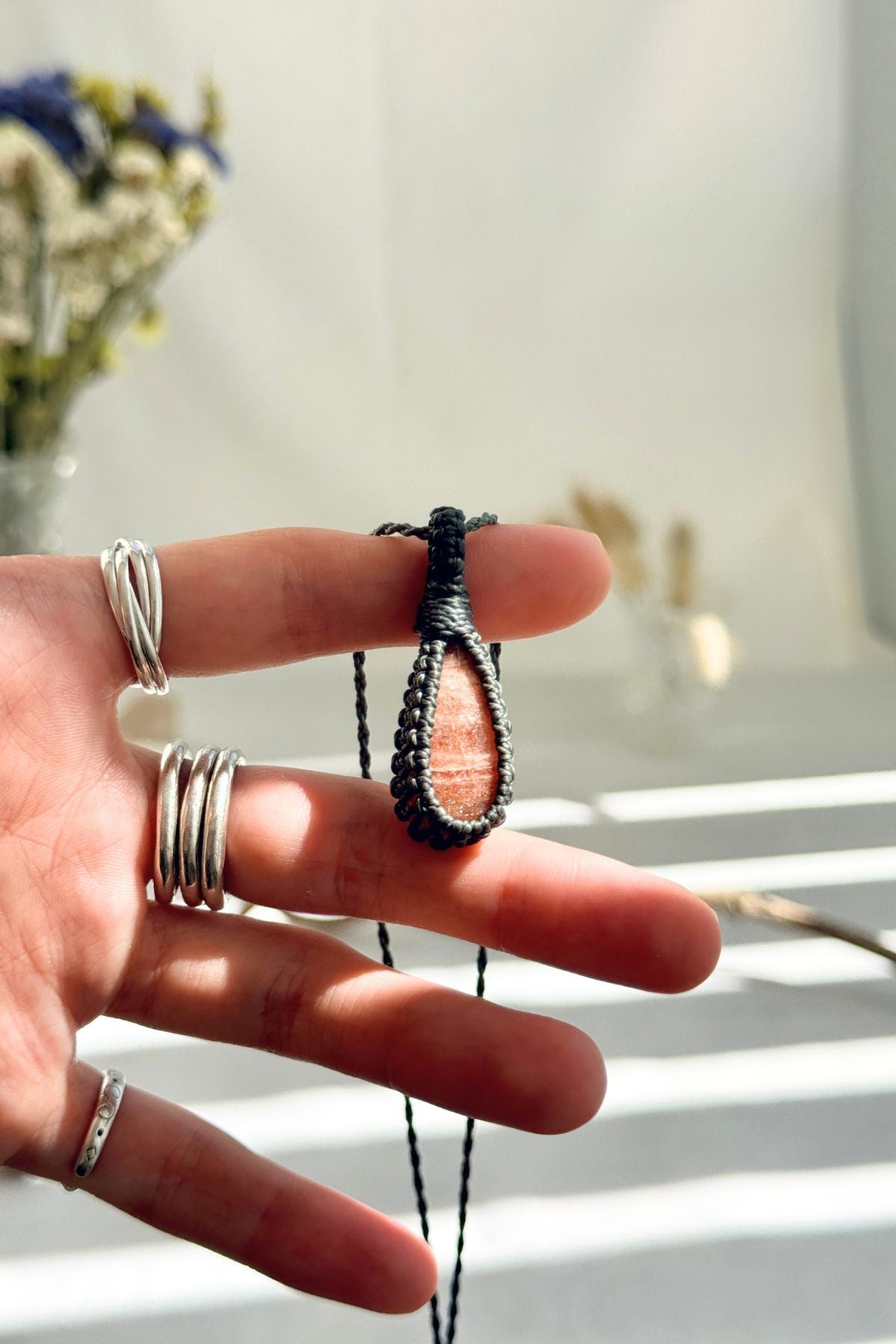 Handmade Sunstone macramé necklace held in hand, delicate natural gemstone jewelry