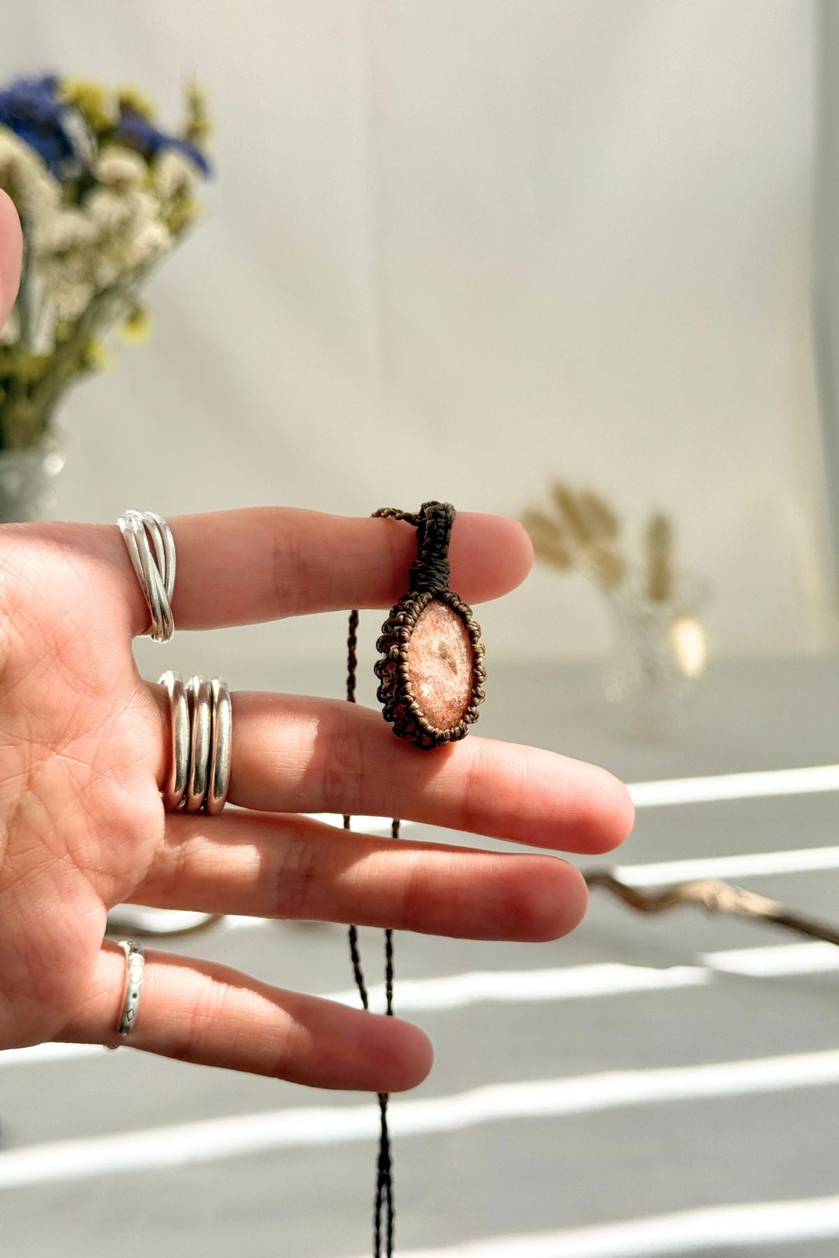 Handmade Sunstone macramé necklace held in hand, delicate natural gemstone jewelry