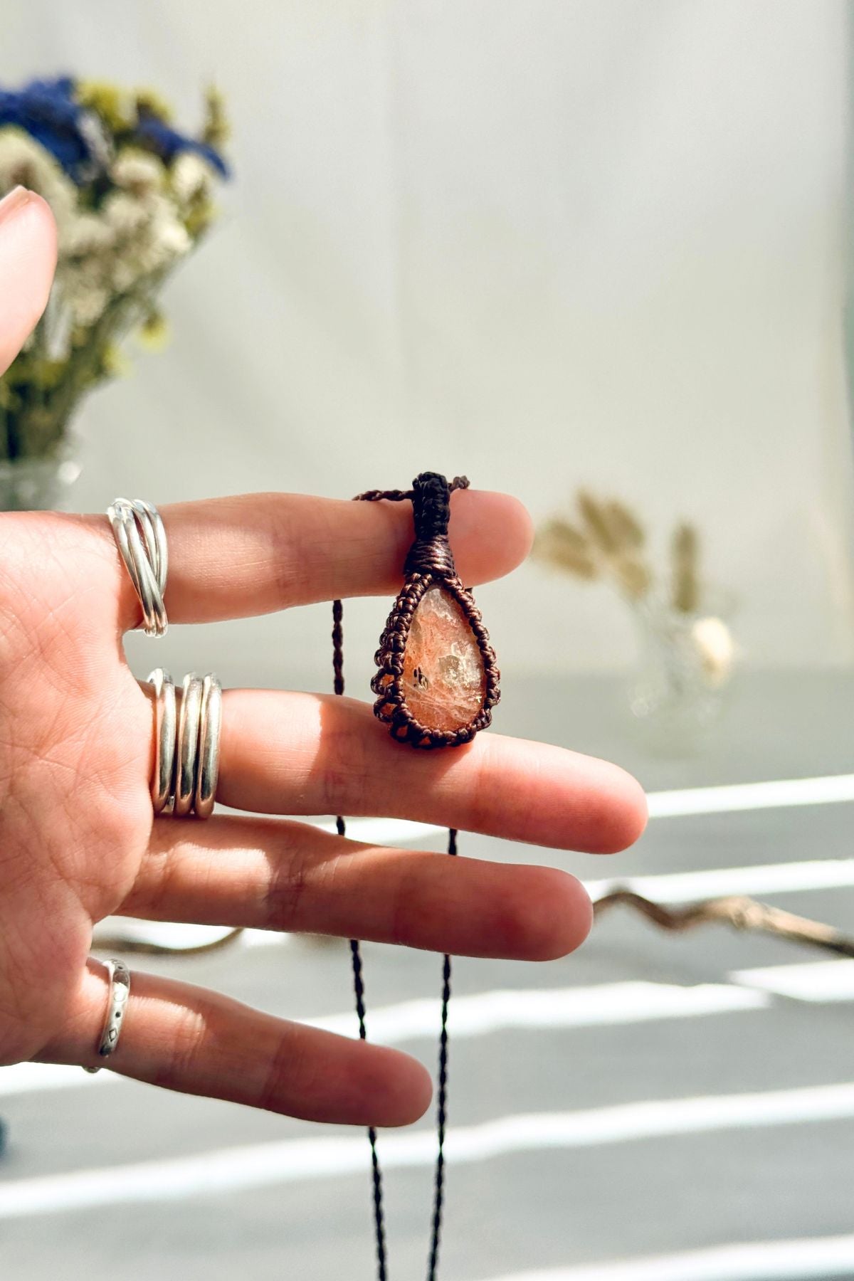 Handmade Sunstone macramé necklace held in hand, delicate natural gemstone jewelry