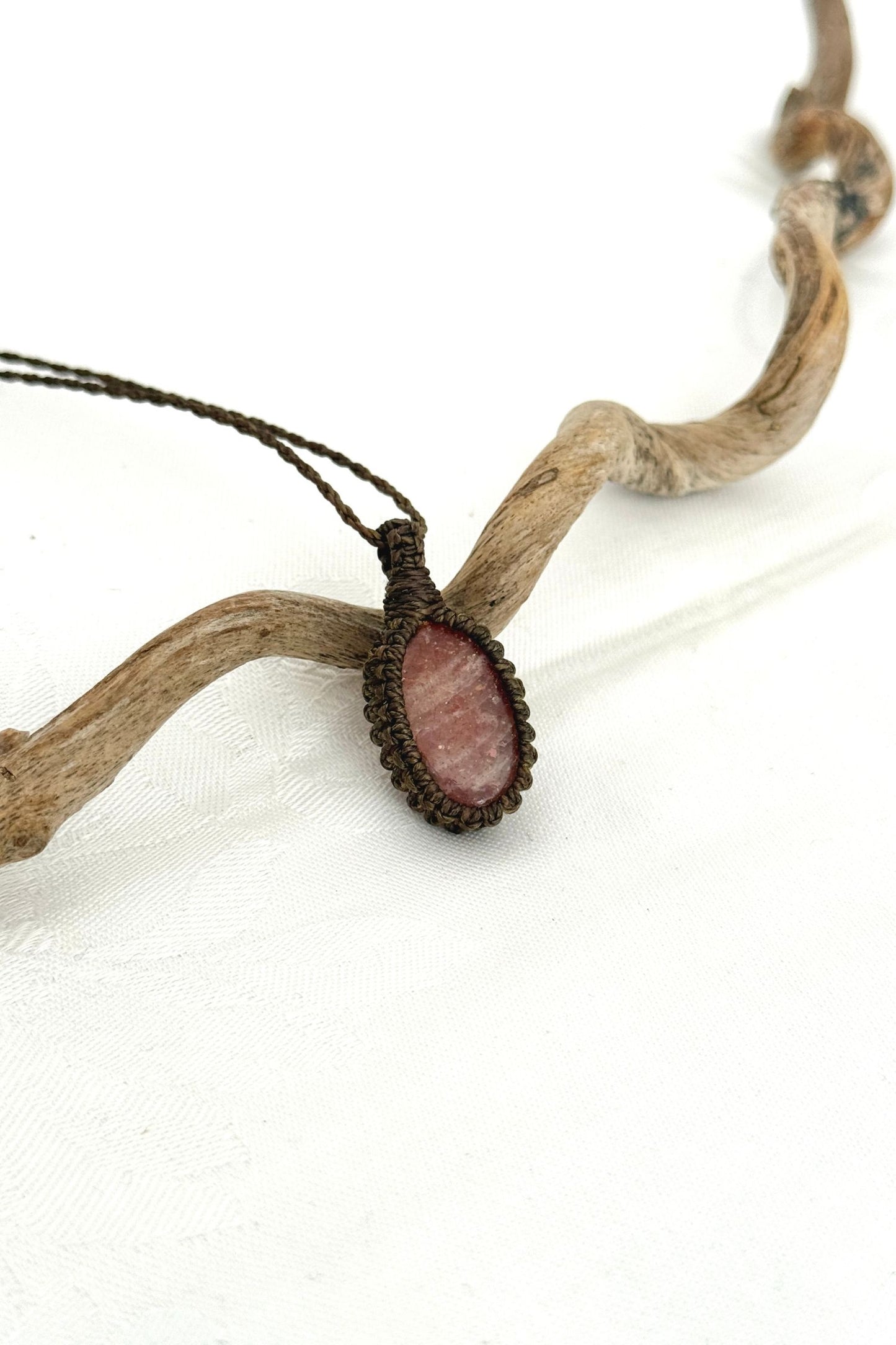 Side view of a Sunstone macrame necklace wrapped in dark green cord, highlighting its elegant craftsmanship.