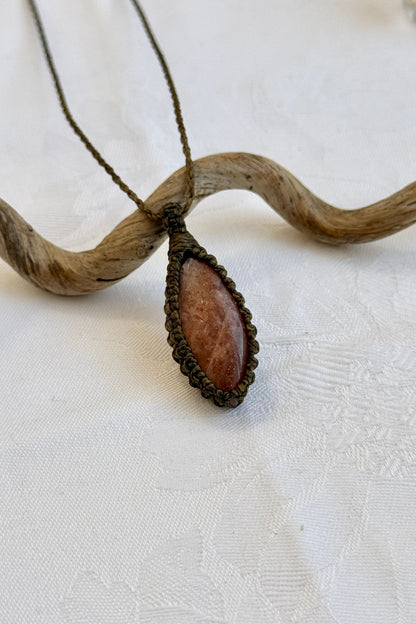 Close-up of handmade Sunstone Macrame necklace, showcasing the intricate macrame knotting and the vibrant patterns of the gemstone.