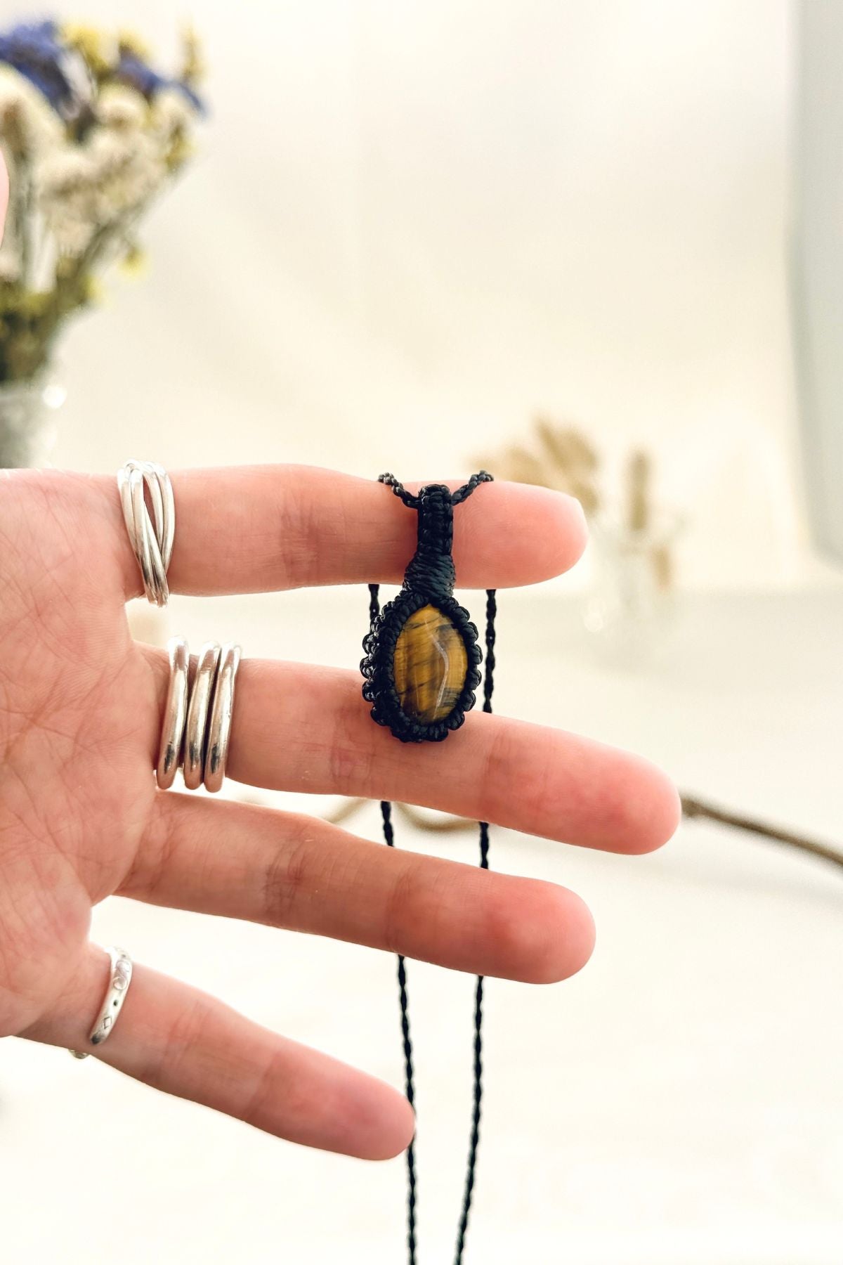 Handmade Tiger’s Eye macramé necklace held in hand, delicate natural gemstone jewelry