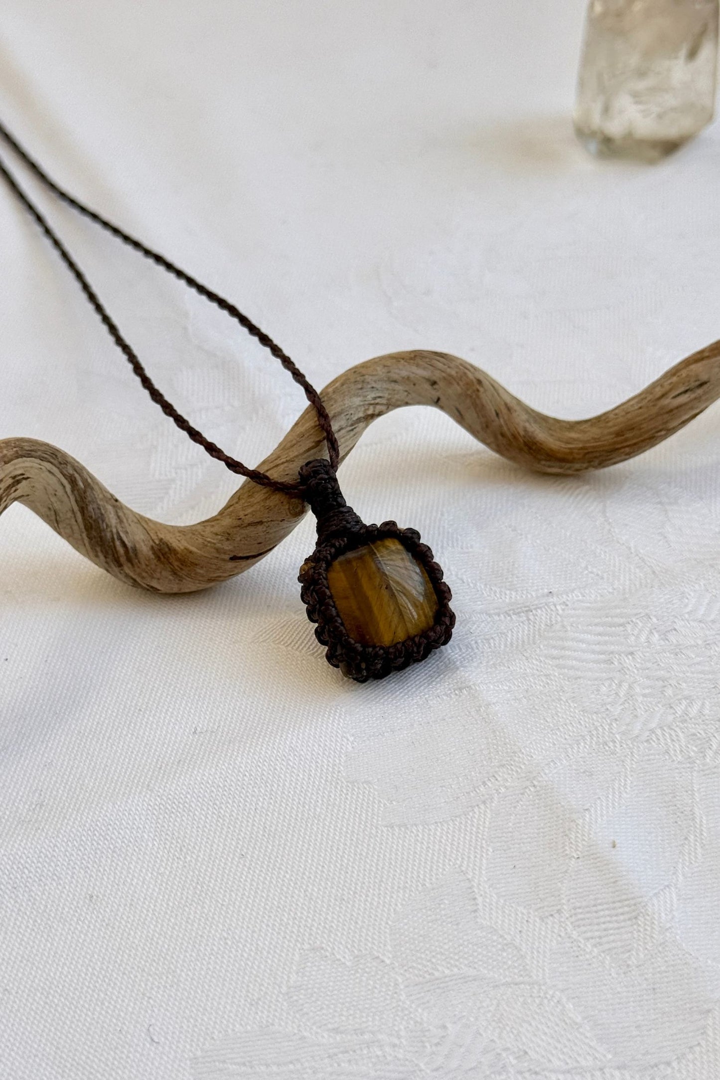 Side angle view of the Tiger’s Eye Macrame necklace, showing the fine macrame details and the unique gemstone centerpiece.