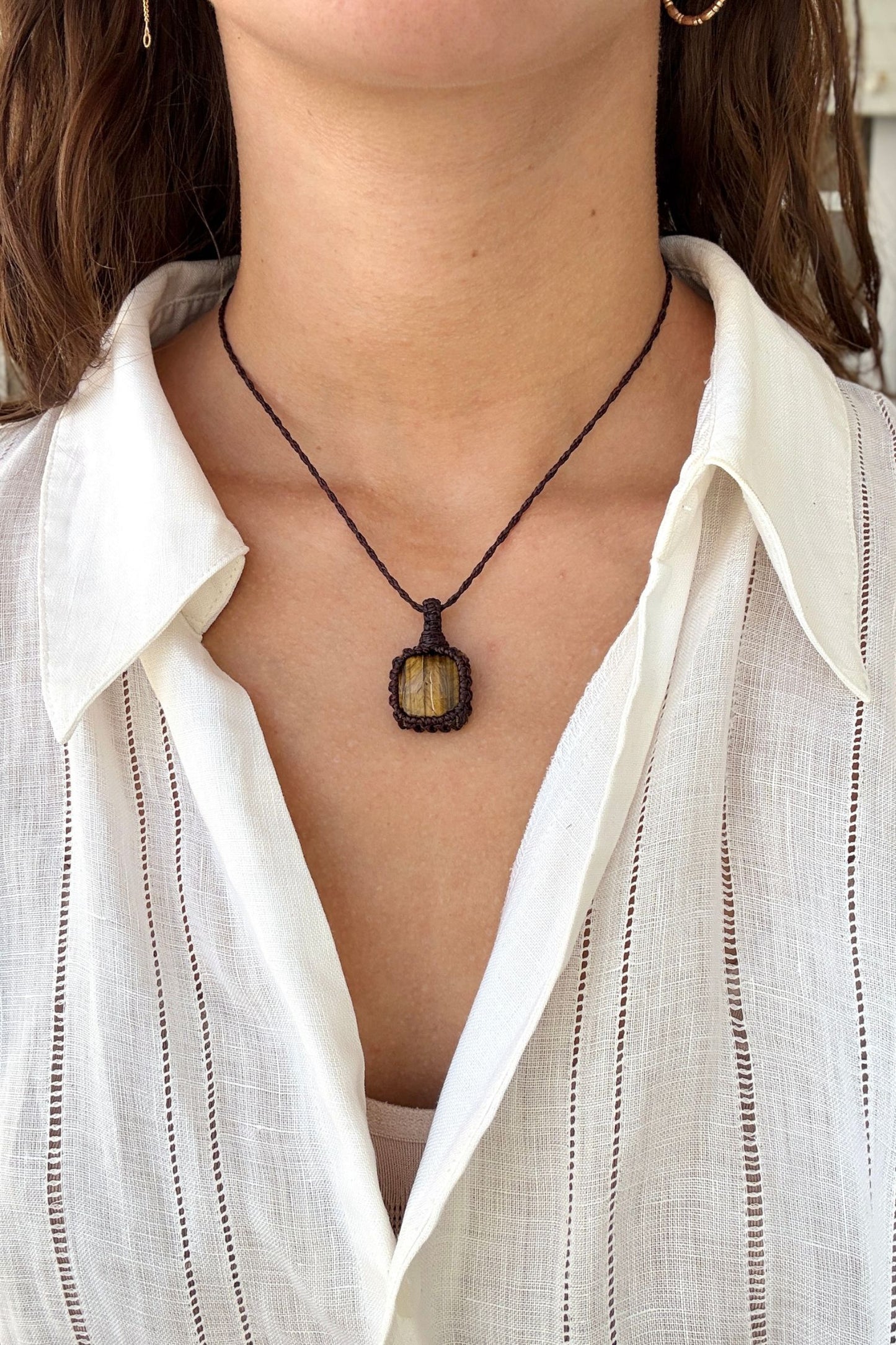 Model wearing a delicate handmade Tiger’s Eye macrame necklace with a brown cord, perfect for everyday wear.