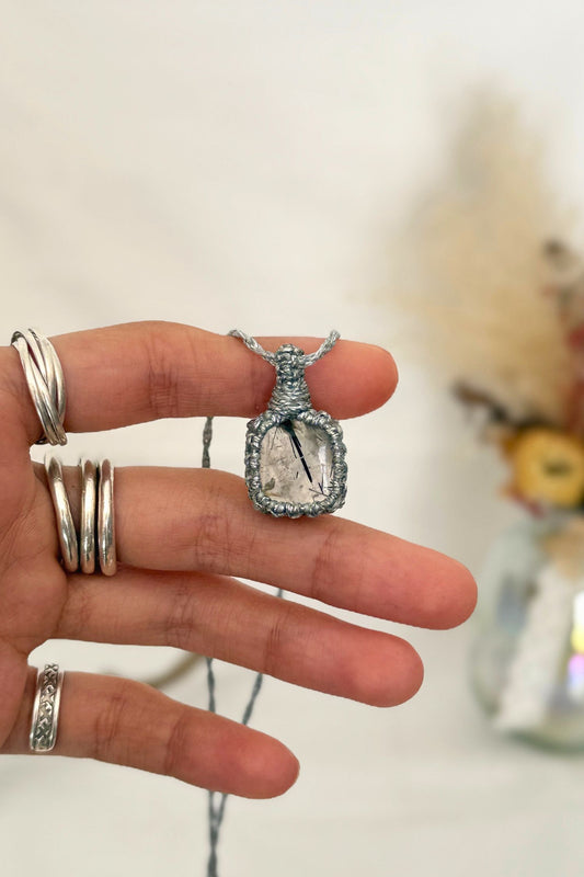 Hand holding a handmade Tourmaline QuartzMacrame necklace from the Essence collection, featuring a high-quality gemstone in a delicate everyday-wear design.
