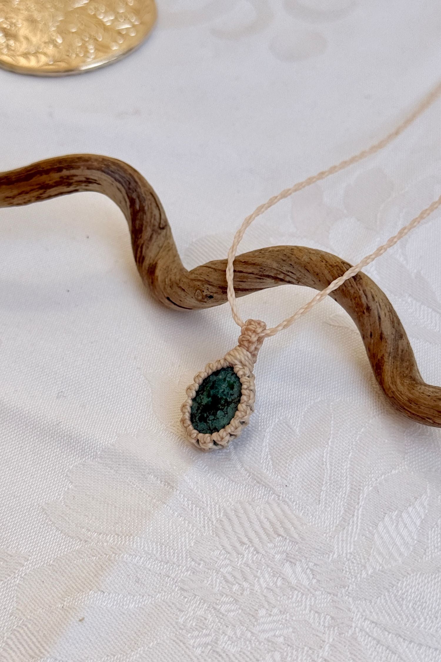 Side angle view of the Turquoise Macrame necklace, showing the fine macrame details and the unique gemstone centerpiece.