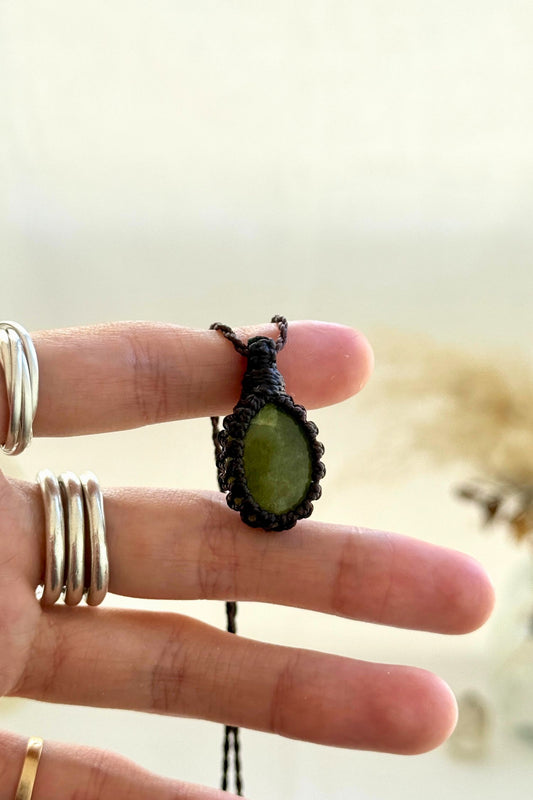 Hand holding a handmade Vesuvianite Macrame necklace from the Essence collection, featuring a high-quality gemstone in a delicate everyday-wear design.